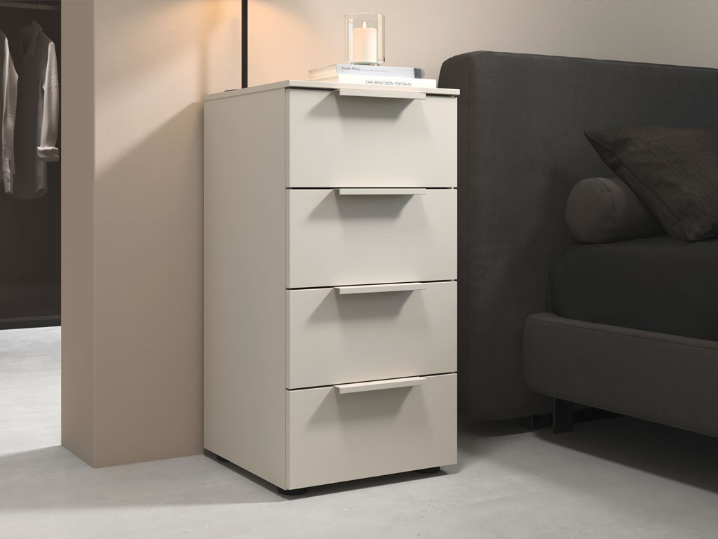 grauer nachttisch mit vier schubkästen platziert neben einem bett in einem modernen zimmer stilvoll dekoriert