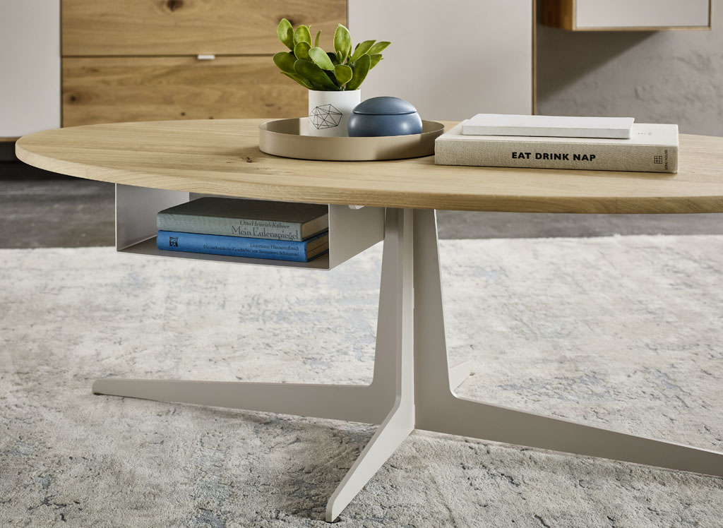 moderner ovaler Holzcouchttisch mit hellem Metallgestellt stilvoll dekoriert in einem modernen Raum auf graue meliertem Teppich