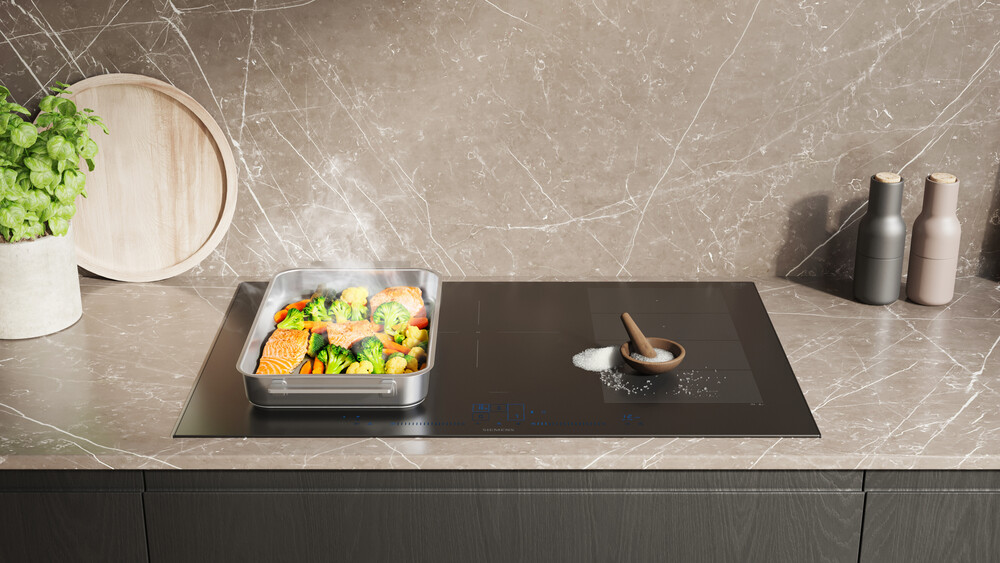 Induktionskochfeld mit Gemüse in einer Pfanne und Salz auf dem Kochfeld, ohne Kratzer