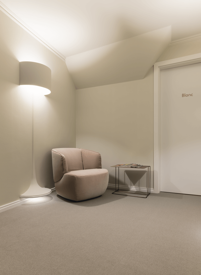 Ein bequemer Sessel neben einer modernen Stehlampe in einem ruhigen Raum