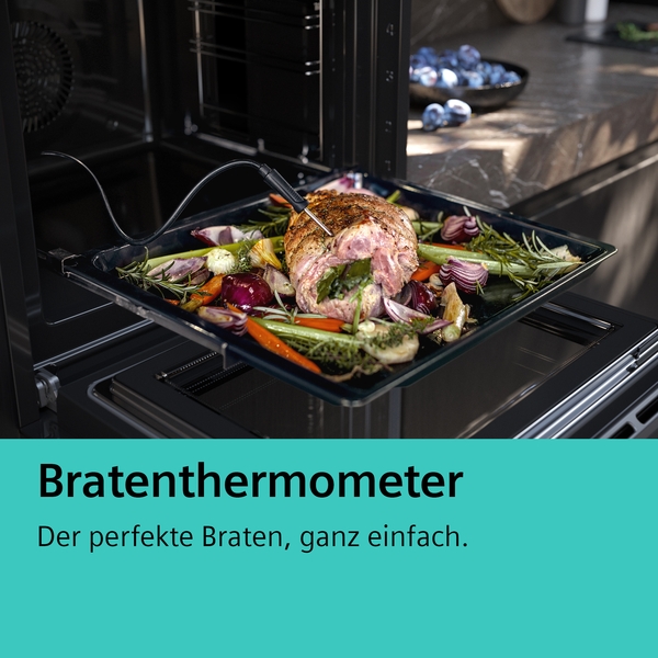 Bratenthermometer misst Temperatur eines Bratens mit Gemüse im Ofen