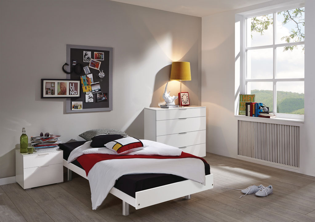 Weißes Einzelbett aus MDF mit alufarbenen Füßen, schwarz-weißer Bettwäsche und roter Decke in einem modern eingerichteten Jugendzimmer