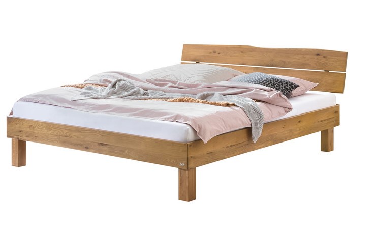 braunes Holzbett mit Kopfteil matratze mit weißem bezug und bettschwäsche vor weißem hintergrund hasena