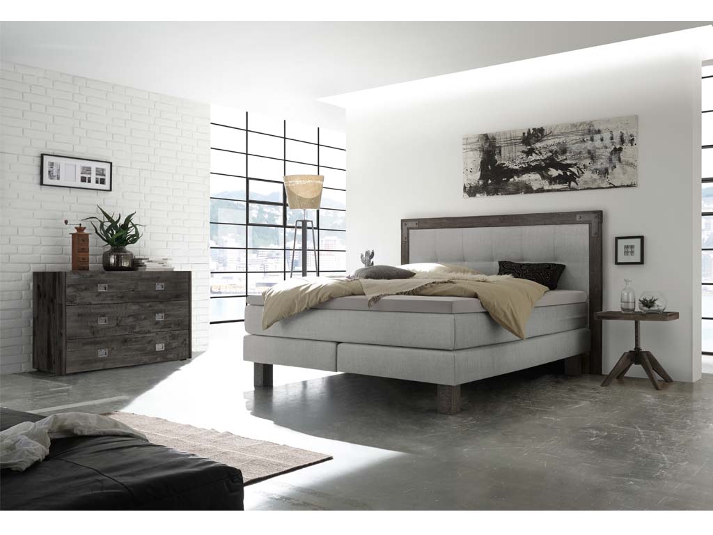 Kommode aus schwarzem eichenholz mit sechs markanten griffen aus metall eingelassen in der front stilvoll dekoriert in einem modernen schlafzimmer calino von hasena