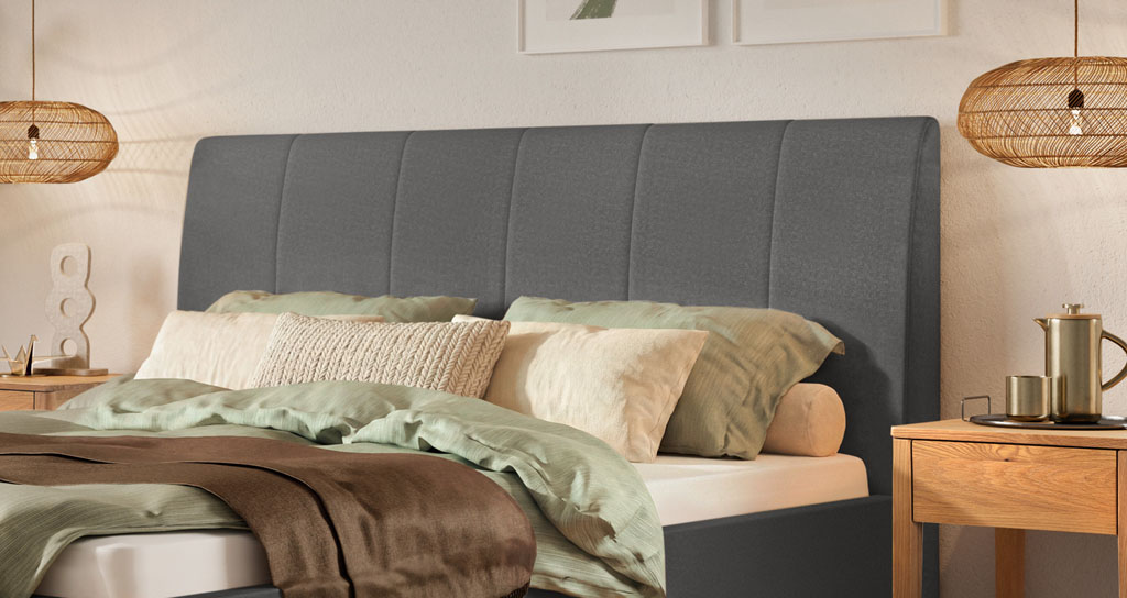 Nahaufnahme des dunkelgrauen Kopfteils mit vertikaler Steppung eines modernen Polsterbettes im Schlafzimmer (KI-generiert)