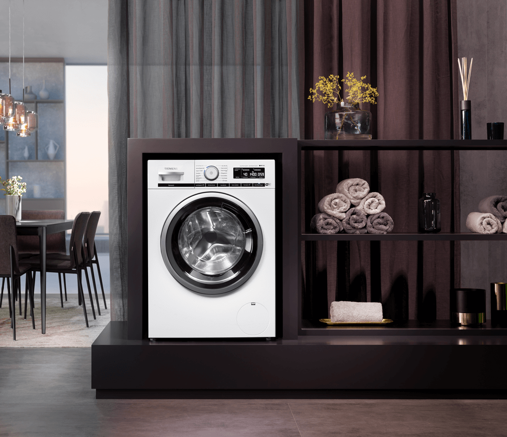 Siemens Waschmaschine mit verschiedenen Accessoires und gemütlichem Hintergrund.