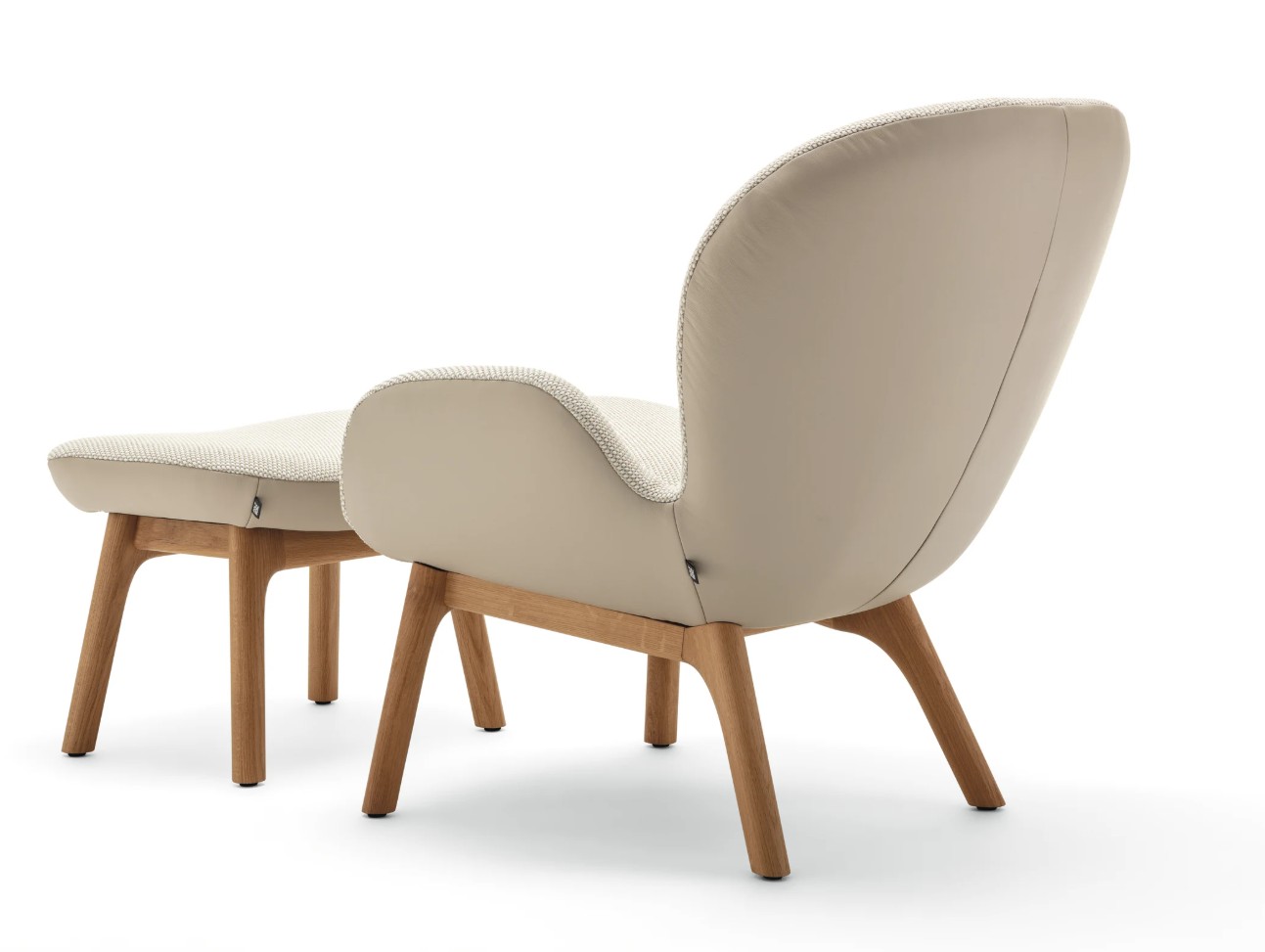 markant gepolsterter Designersessel zweifarbig beige mit braunem Holzgestell mit passendem Hocker vor weißem Hintergrund