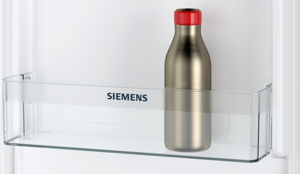 Eine Edelstahlflasche mit rotem Deckel steht in einem Siemens Kühlschranktürfach.