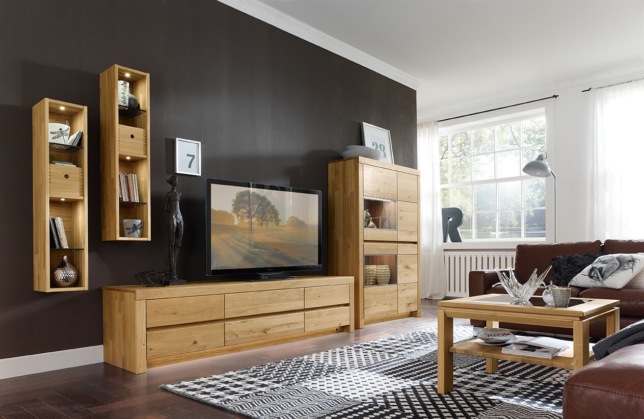 Wöstmann Soleo 3000 - Wohnwand, 4-teilig | Type 3001/3101 | B: 377,3 cm | konfigurierbar Modernes Wohnzimmer mit Holzmöbeln, darunter eine Wohnwand mit TV, Hängeregale und Couchtisch, in einer eleganten Einrichtung mit natürlichem Licht.