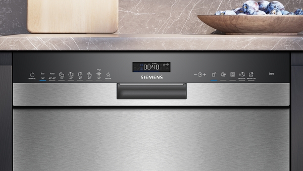 Nahaufnahme einer Siemens-Geschirrspülmaschine mit digitalem Display und Edelstahloberfläche, eingebaut in eine Kücheneinrichtung.