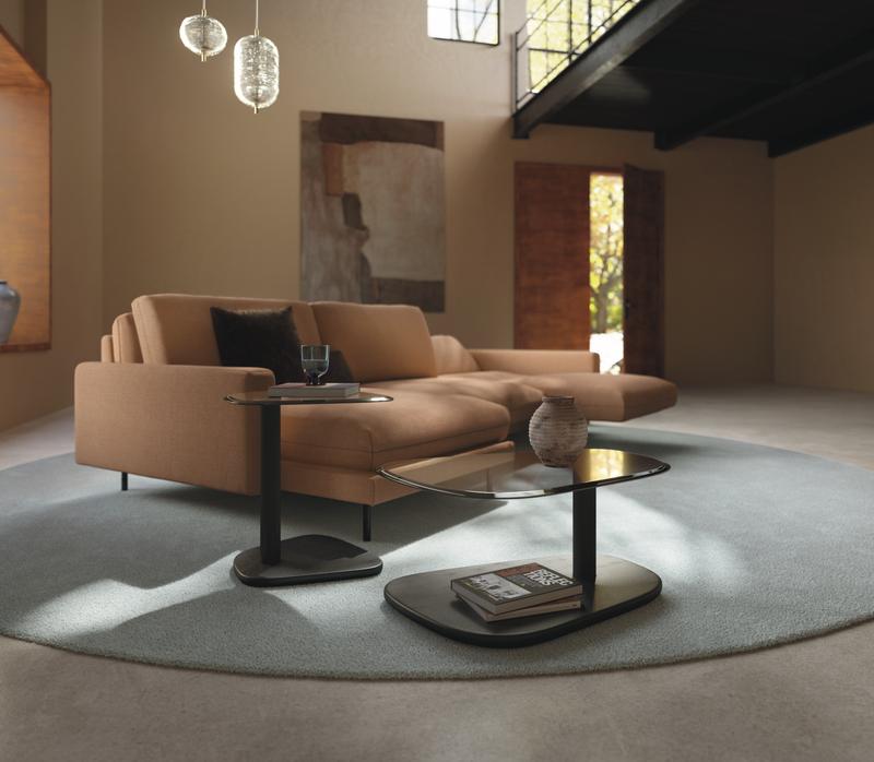 modernes cognacfarbiges Sofa in einem mit zwei markanten beistelltische mit glasplatte in einem extravaganten raum