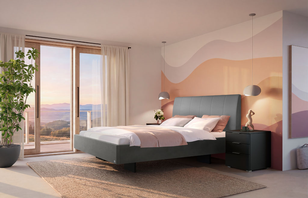 Graues Polsterbett mit vertikal gestepptem Kopfteil und schwarzen Füßen in einem hellen, modern eingerichteten Schlafzimmer mit gemusterter Wandgestaltung (KI-generiert)