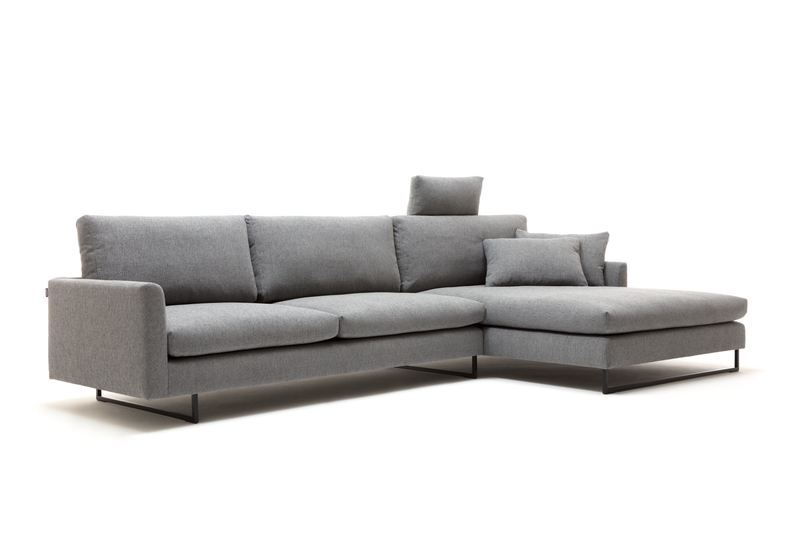 Ein stilvolles, graues Ecksofa mit Chaiselongue und zusätzlichen Kissen auf weißem Hintergrund