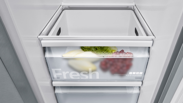 Blick in ein Kühlfach mit frischem Salat, Trauben und Gemüse