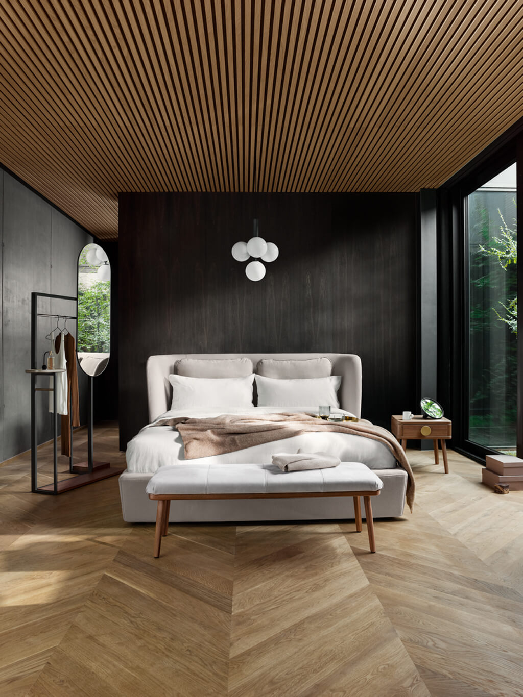 Ein modernes Schlafzimmer mit eleganter Holzdecke, einem großen Bett mit weißer Bettwäsche und einer Sitzbank, umgeben von stilvollen Möbeln und großen Fenstern.