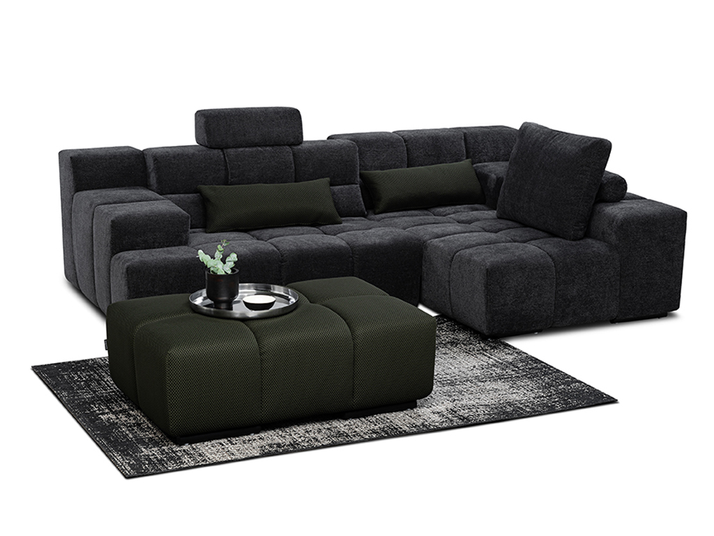 Modulares Sofa in Dunkelgrau mit Hocker und schwarzem Tablett auf einem gemusterten Teppich