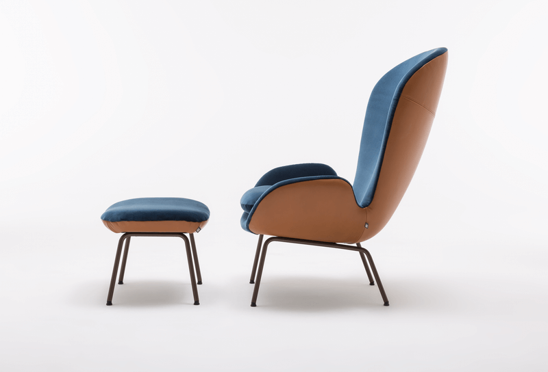 Seitenansicht eines modernen Sessels mit passendem Hocker in Blau und Braun auf weißem Hintergrund