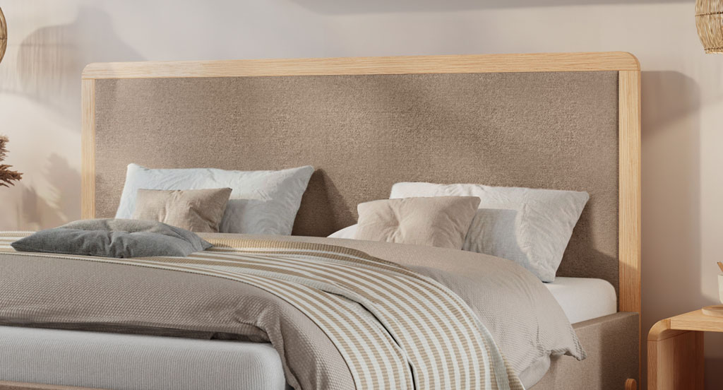 Nahaufnahme des sandfarbenen Kopfteils mit massivem Eichenholzrahmen an einem modernen Polsterbett (KI-generiert)