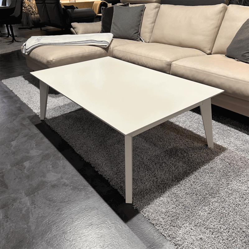 RMW SIENA | Couchtisch Ein eleganter, weißer Couchtisch vor einem beigen Sofa, platziert auf einem grauen Teppich in einem stilvoll eingerichteten Wohnzimmer.