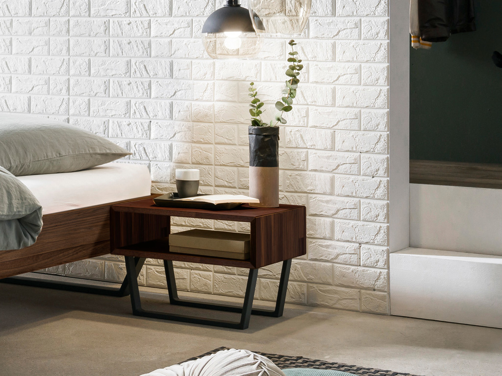 brauner Nachttisch auf schwarzen Kufen und in Form eines offenen Faches stilvoll dekoriert in einem freundlichen zimmer Jose von Hasena