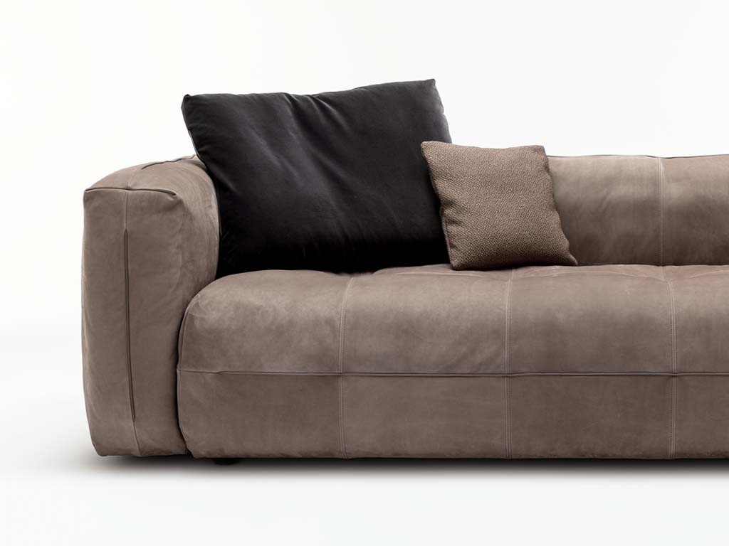 Rückenkissen in schwarz und kleines Kissen in hellem braun auf brauner Ledercouch 