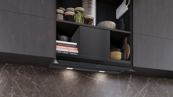 Geöffneter Oberschrank mit integrierter Dunstabzugshaube, der trotz Einbau noch Stauraum für Kochbücher und Vorratsgläser bietet.