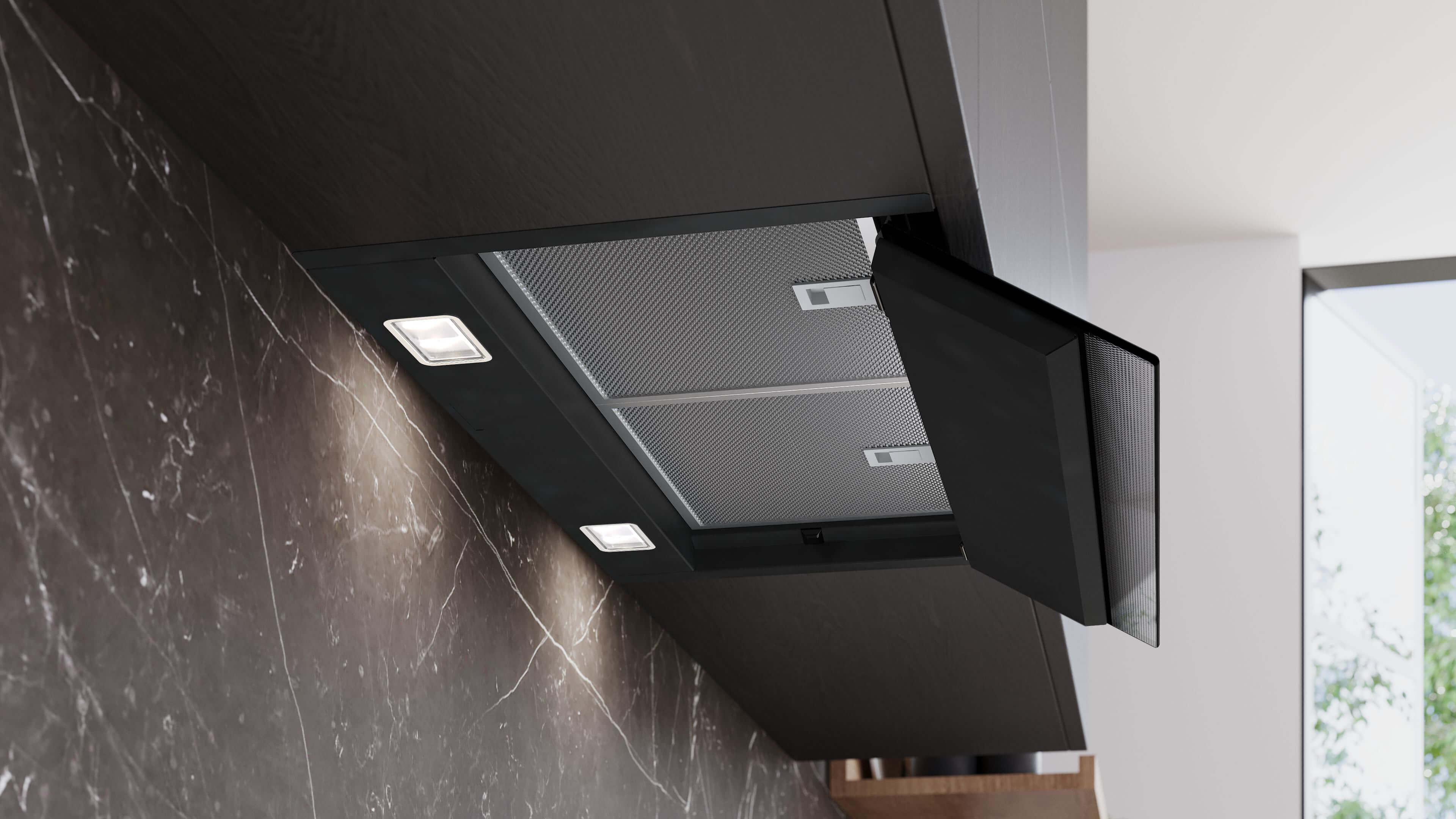 Ansicht der schwarzen Dunstabzugshaube mit heruntergeklappter Frontklappe, die die dahinterliegenden Metallfettfilter und die hellen LED-Leuchten freigibt.