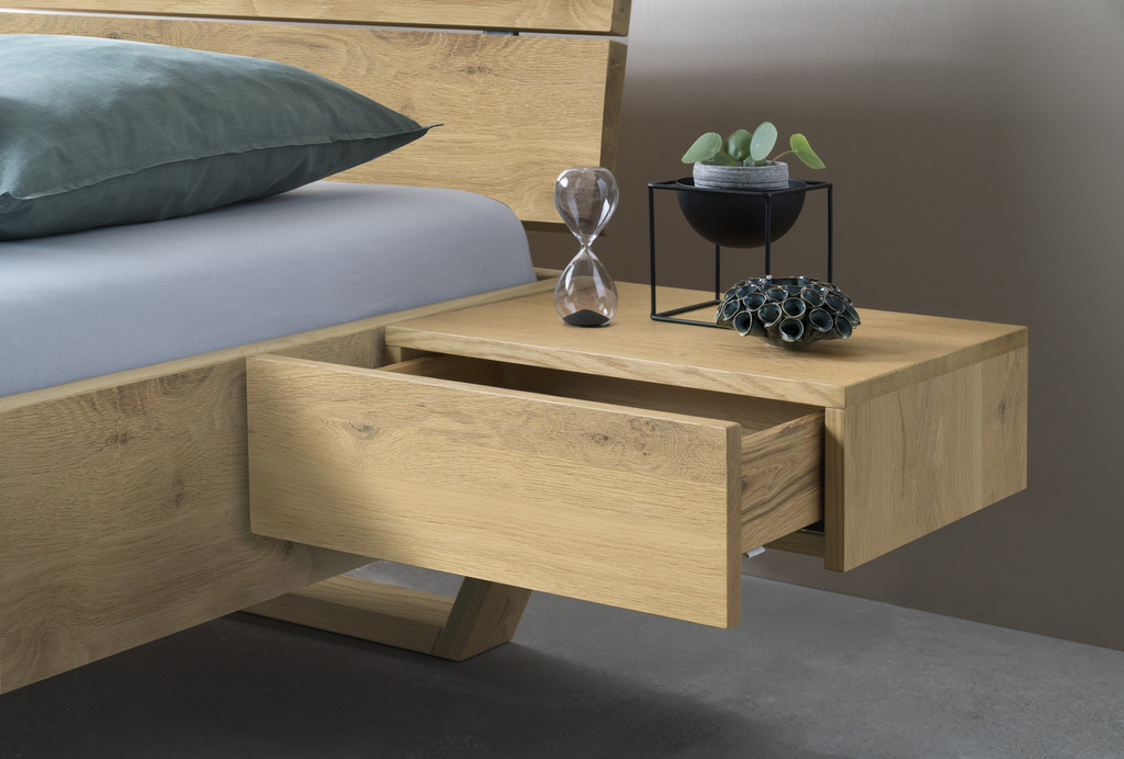 Hasena - Caja Nachttisch mit 1 Schublade | B: 48 cm | alle Ausführungen konfigurierbar Detailaufnahme eines modernen Hängenachttisch mit einer offenen Schublade in hellbraunem Holz stilvoll dekoriert von Hasena
