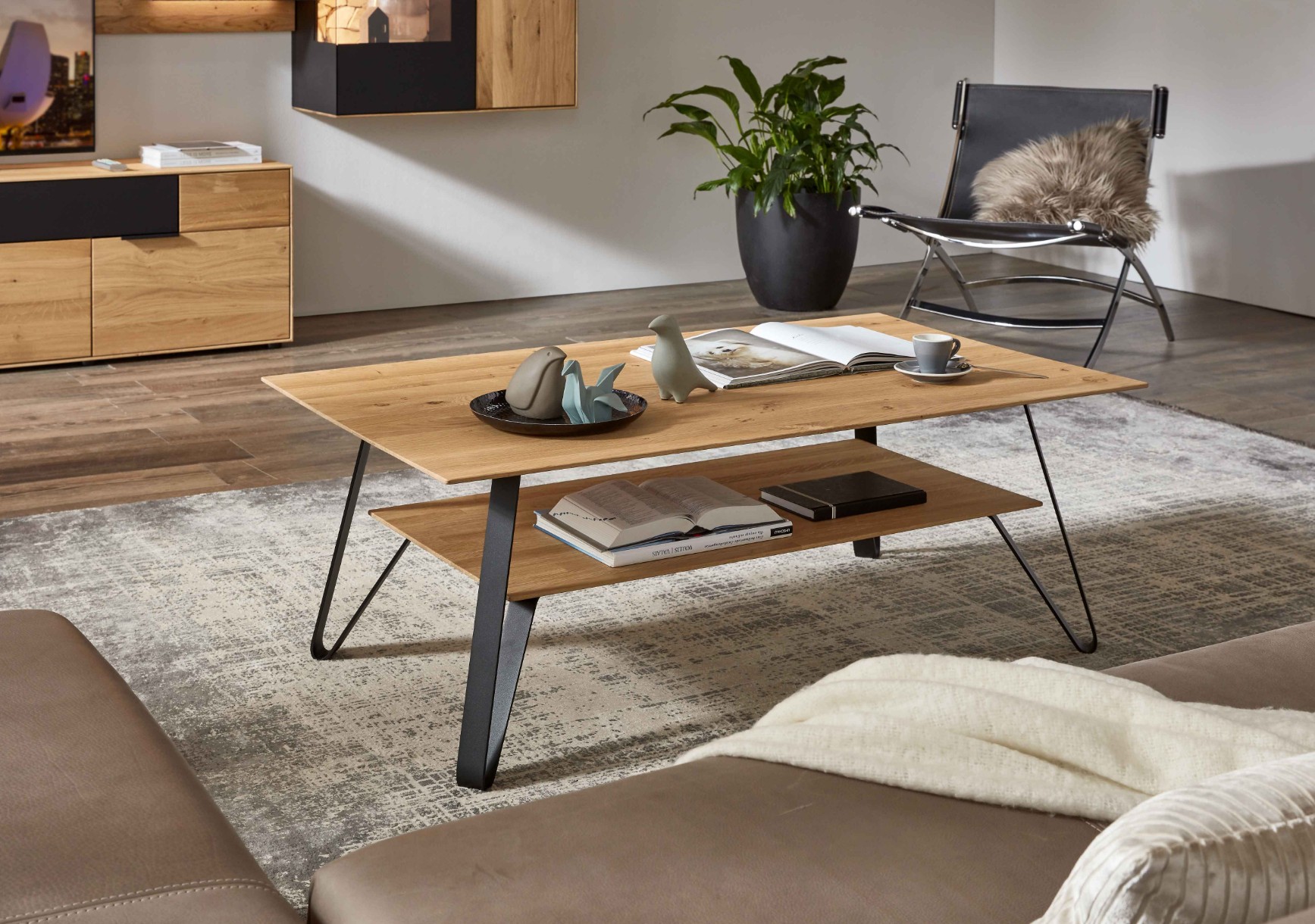 moderner Holzcouchtisch im mit Metallfuß und integrierter Ablage stilvoll dekoriert in einem modernen Raum