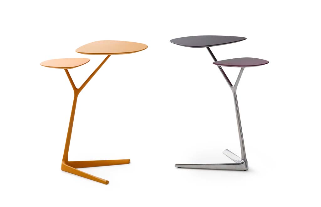 Zwei moderne Beistelltische, einer in Orange und einer in Chromoptik, mit asymmetrischem Design und glatten Oberflächen