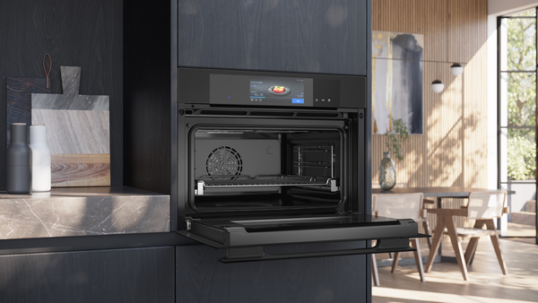 Siemens studioLine Einbau-Kompaktbackofen mit geöffneter Klapptür in einer modernen Wohnküche.