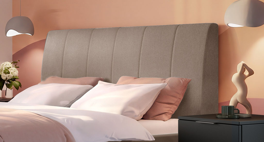 Nahaufnahme des sandfarbenen Polsterkopfteils mit vertikaler Steppung vor einer gemusterten Wand in einem Schlafzimmer (KI-generiert)