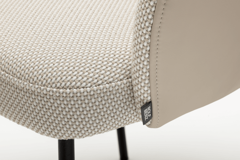 Detailansicht eines Stuhls mit beige gemustertem Stoff und ledernen Seiten, Roset Etikett sichtbar