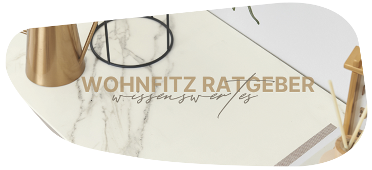Goldene Kanne und Stiftehalter auf marmorierter Oberfläche, daneben text Wohnfitz Ratgeber - Wissenswertes