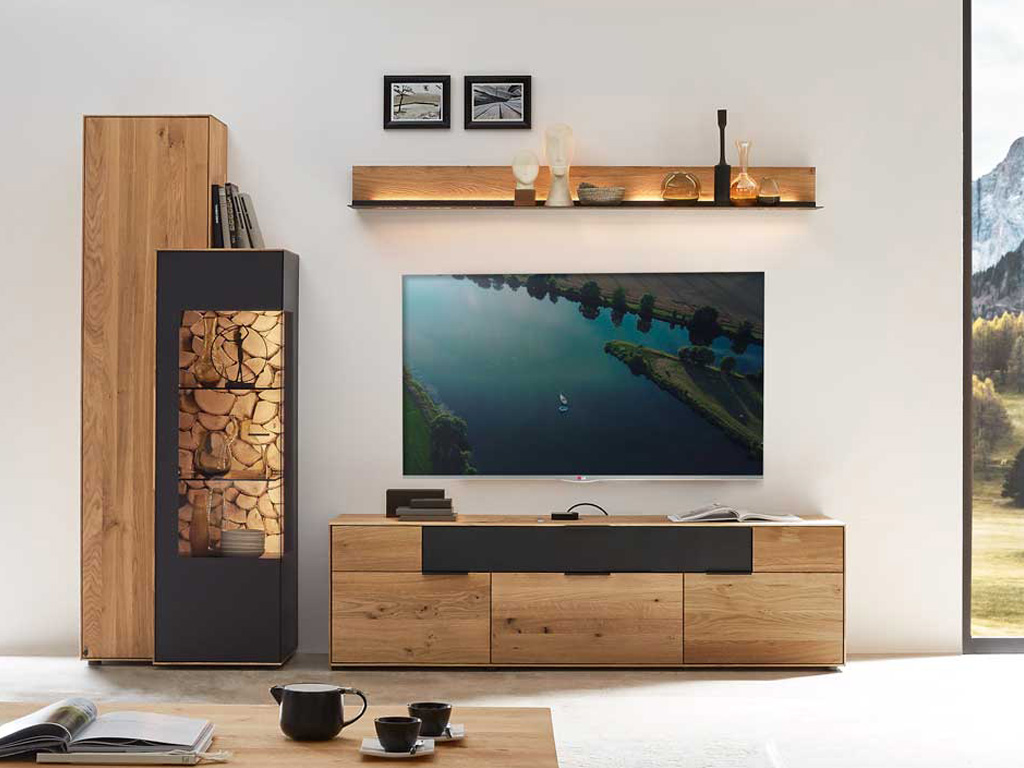 Wöstmann WM 2140 - Wohnwand  | Type 0004/0104 | Wildeiche massiv | konfigurierbar Wohnzimmer mit stilvollem Möbelset bestehend aus TV-Schrank, Wandregal und Holzvitrine, modernen Dekorationsobjekten und einem Flachbildfernseher.