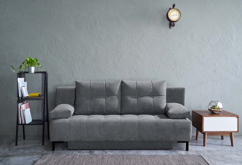Restyl Wayne - Schlafsofa (Querschläfer) | grau | mit Bettkasten | 140 x 196 cm Wohnzimmer mit grauem Sofa, Beistelltisch, Bücherregal und Wanduhr in modernem Design