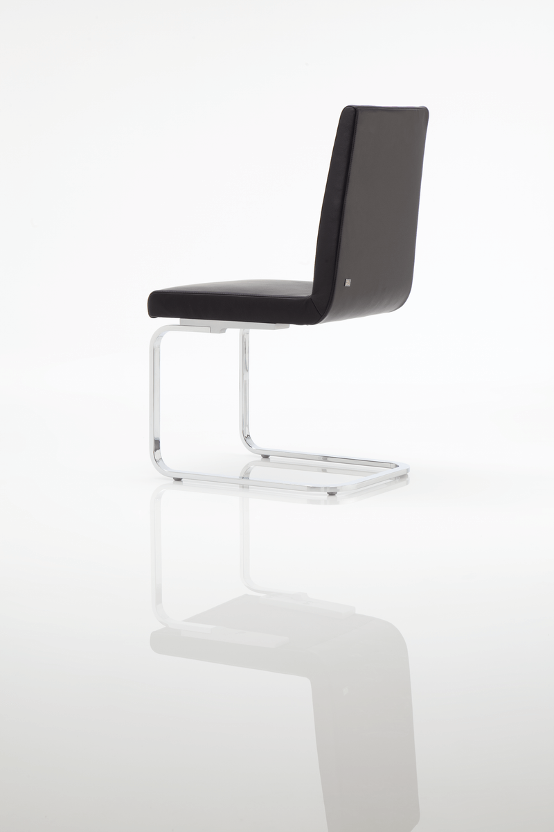 Seitansicht eines modernen Freischwinger Stuhls mit schwarzem Polster und Chromgestell