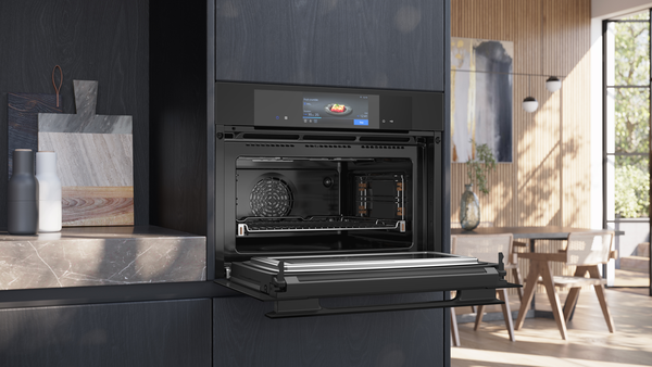 Einbau-Kompaktbackofen von Siemens mit geöffneter Klapptür in einer modernen Wohnküche.