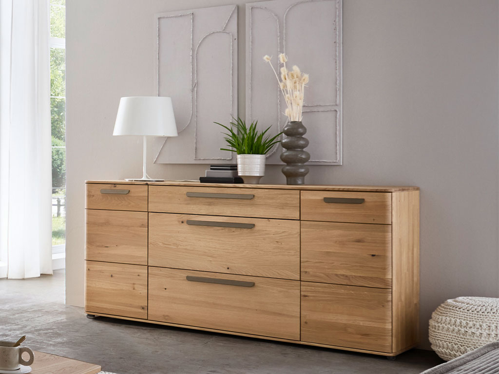 modernes Sideboard aus Holz mit markanten griffen stilvoll dekoriert in einem modernen zimmer