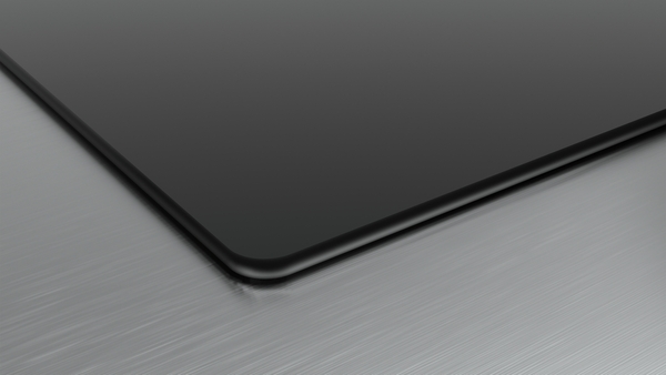 Nahaufnahme einer Tablet-Ecke auf einer gebürsteten Metalloberfläche