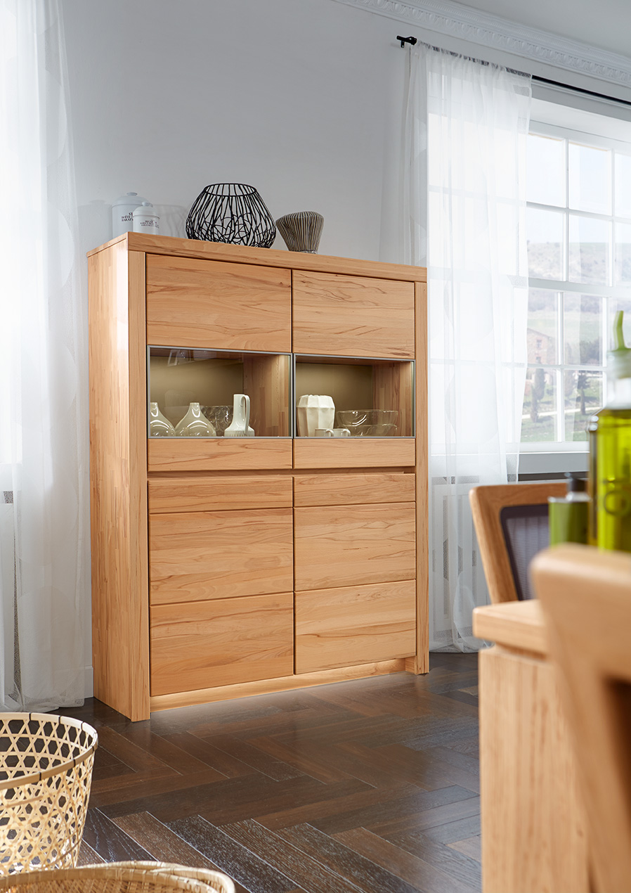 Wöstmann Soleo 3000 - Schrank | Type 4340 | B: 131,2 cm | konfigurierbar Hochwertiger Schrank aus hellem Holz mit Glaseinsatz, steht in einem stilvollen, gut beleuchteten Raum mit Parkettboden