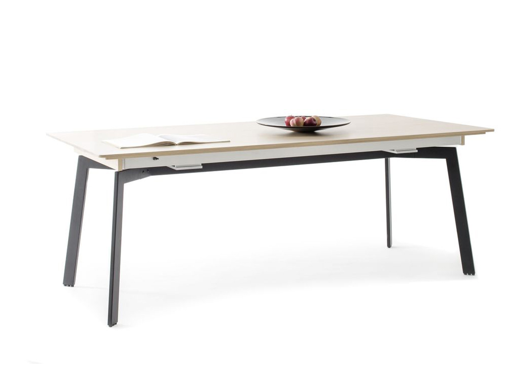 Sudbrock Dana - Esstisch mit Auszug | B: 180 cm | Lack cosmos-schwarz, Eiche milk massiv Moderner Esstisch mit hellem Holz und schwarzen Metallbeinen, dekoriert mit einem Obstteller und einem offenen Buch.