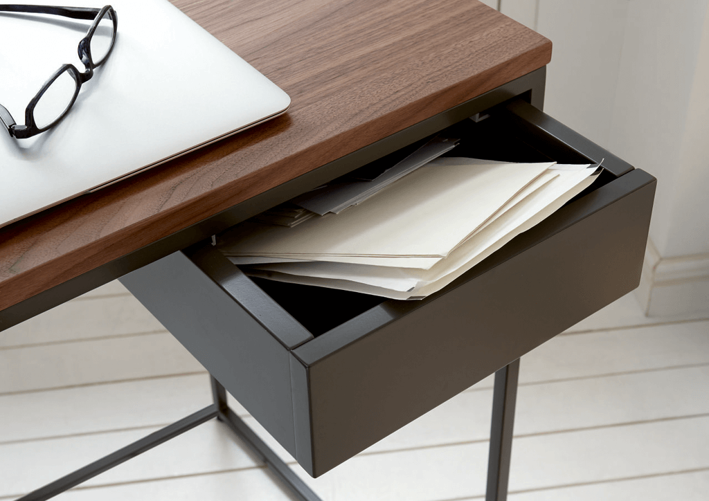 Schublade am Holzschreibtisch mit Brille und Unterlagen