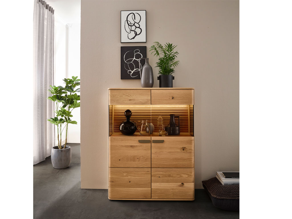 modernes Highboard aus Holz mit einem großen Vitrinenausschnitt und indirekter Beleuchtung stilvoll dekoriert in einem modernen Zimmer