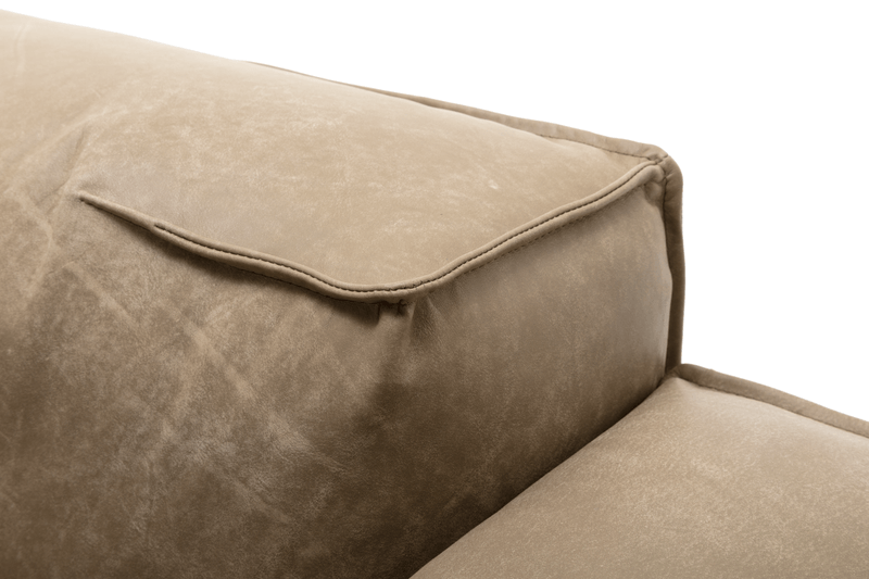 Nahaufnahme eines beigen Sofakissens mit glatter Oberfläche und feiner Naht