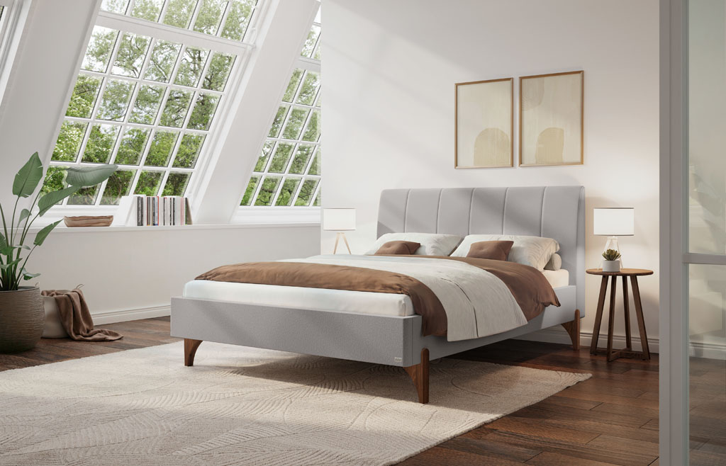 Hellgraues Polsterbett mit vertikal gestepptem Kopfteil und geölten Nussbaum-Holzfüßen in einem modern eingerichteten Schlafzimmer mit Dachfenster (KI-generiert)