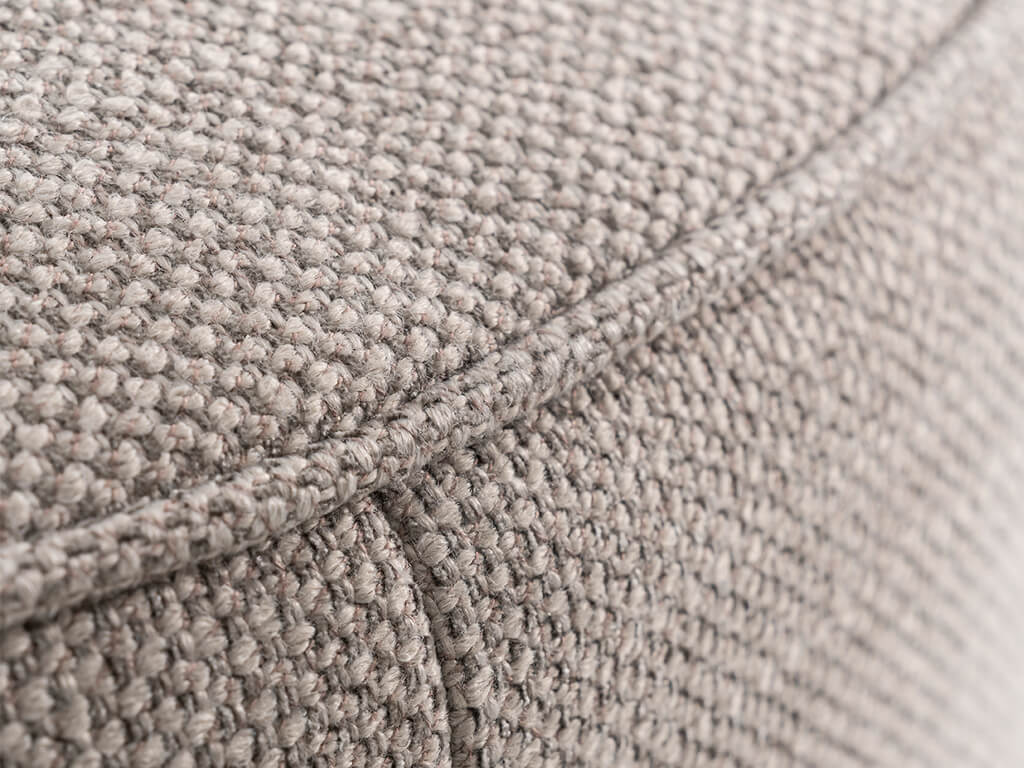 Detailansicht eines grauen, strukturierten Polsterstoffs mit gewebtem Muster