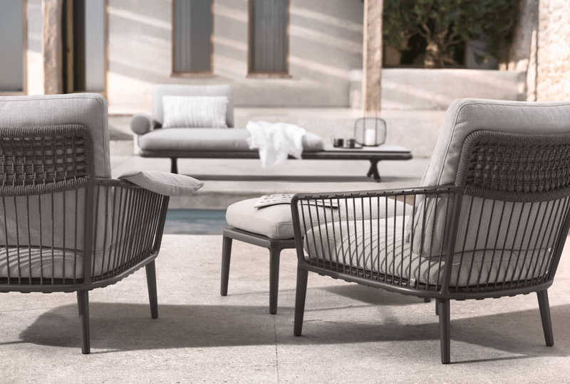 Zwei komfortable Sessel und eine Liege am Pool in stilvollem, modernem Design