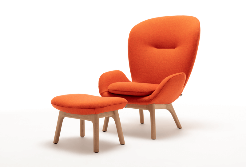 Ein orangefarbener Sessel mit passendem Hocker auf Holzfüßen, zeigt modernes Design und Komfort.