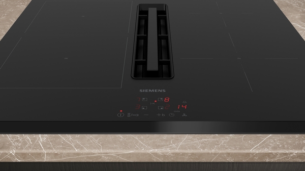 Modernes Induktionskochfeld von Siemens mit integriertem Dunstabzug auf einer Marmorarbeitsplatte